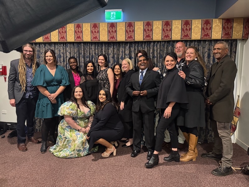 Life Without Barriers staff gathered in a group, smiling at the camera at the Toowoomba NAIDOC Dinner.