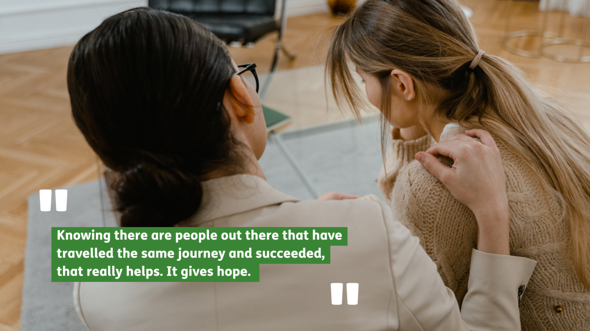 Two women sitting next to each other. One is comforting the other. Text reads: Knowing there are people out there that have travelled the same journey and succeeded, that really helps. It gives hope.