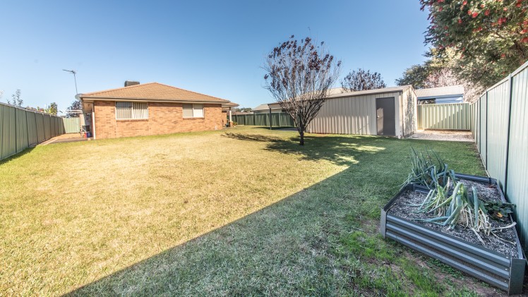 Large backyard with a shed and vegetable planter box.