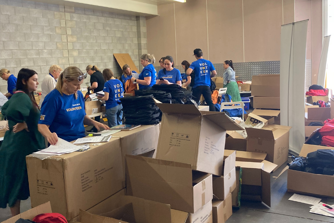 Staff and volunteers gathered around boxes of books, packing the backpacks.