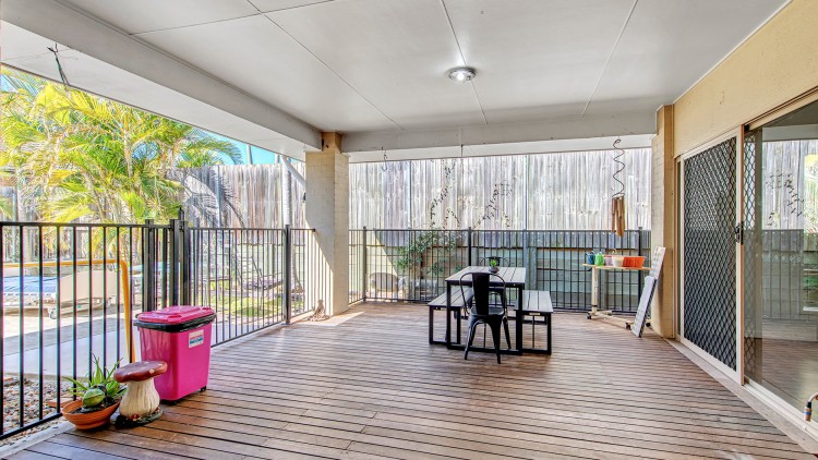 Large outdoor deck with table and sliding doors. 