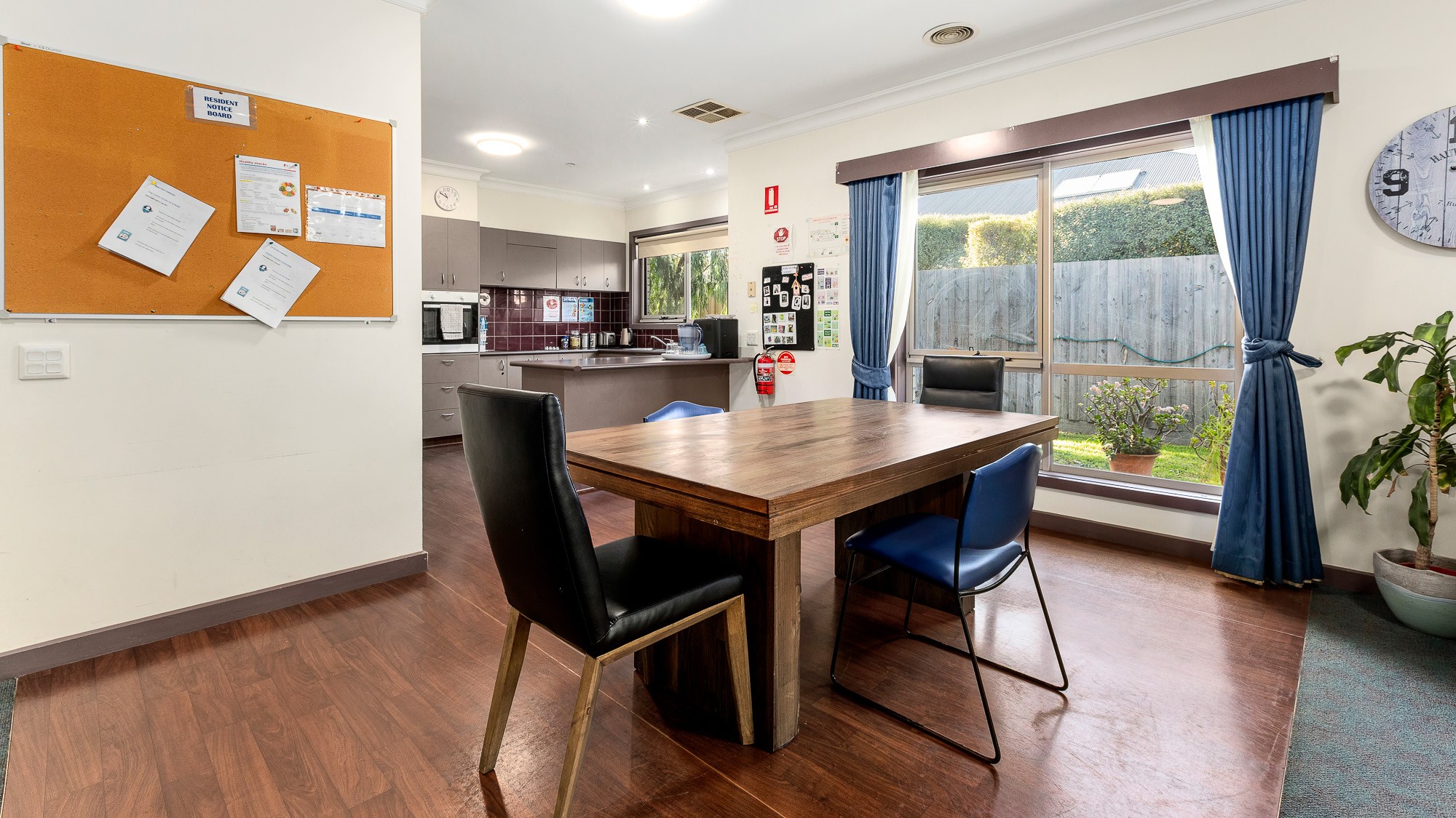 Dining area next to the kitchen, in front of a large window.