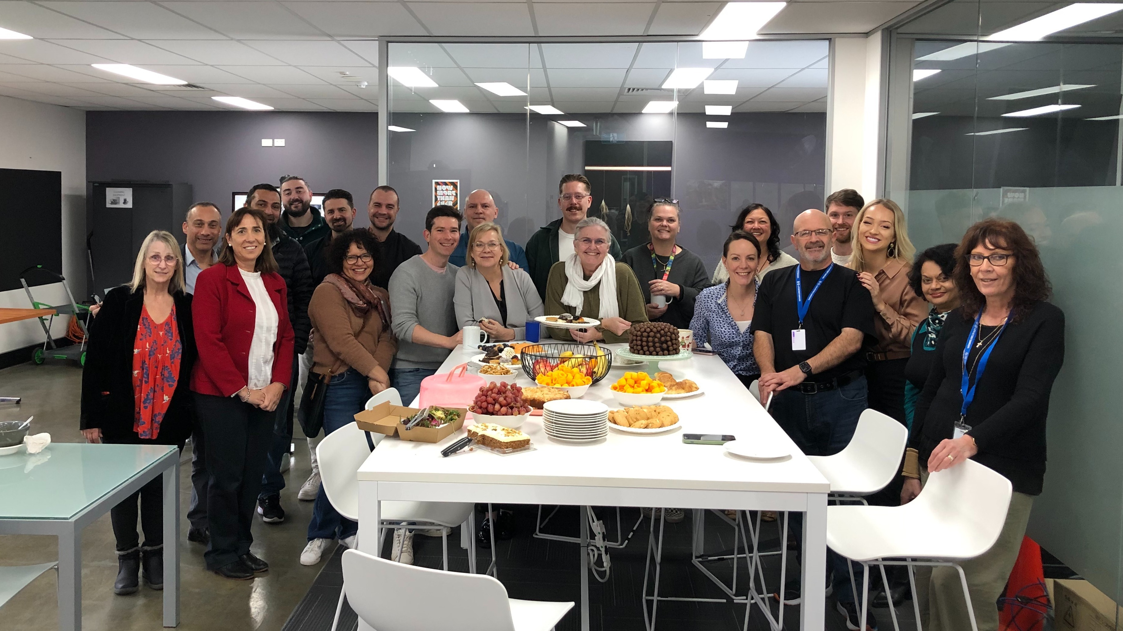 Staff gathered around a table at the Canterbury office. 