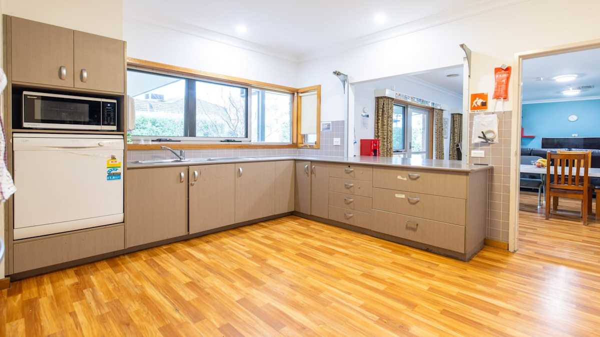 Open plan kitchen with lots of turning space, hard wooden floors and large opening out into the combination dining and loungeroom.