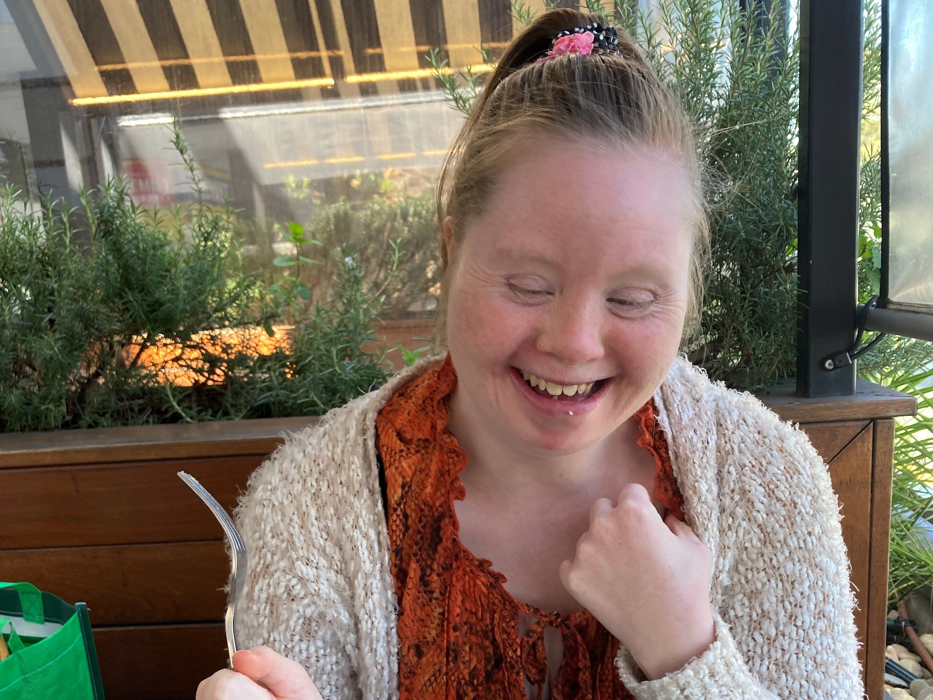 Sam is eating chips, calamari and salad at a sunny cafe.