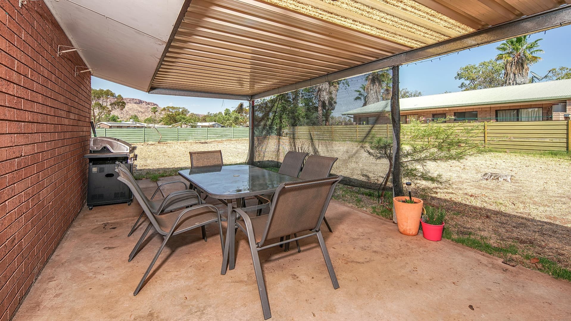 --Back yard with chairs, table and shade.--