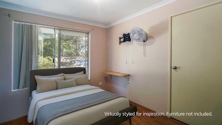 bedroom with soft pink walls, modern double bed, beige bedding, wooden side tables, and wall-mounted fan above a door.