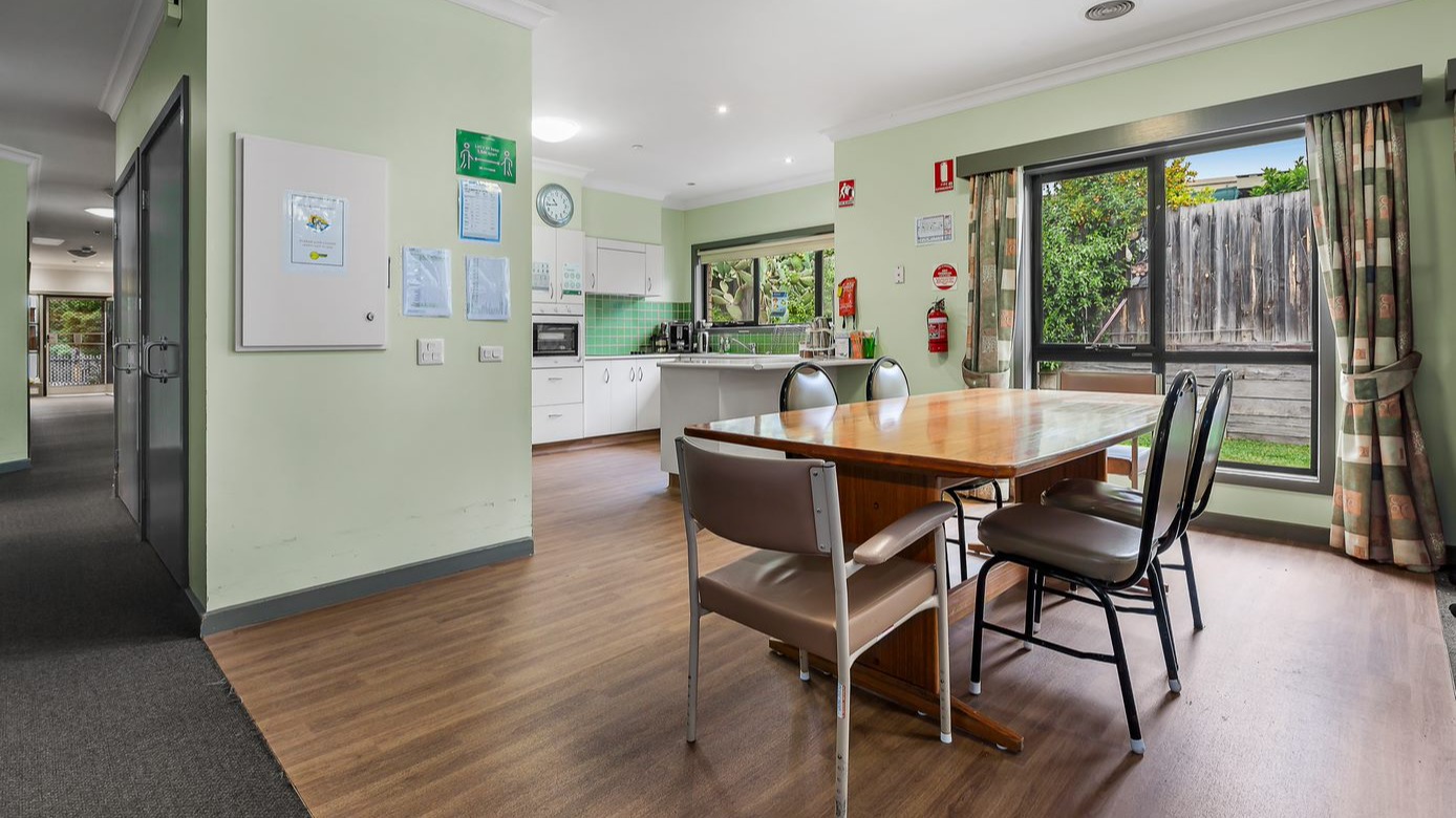 --Dining area next to the kitchen with a wooden table and six chairs.--