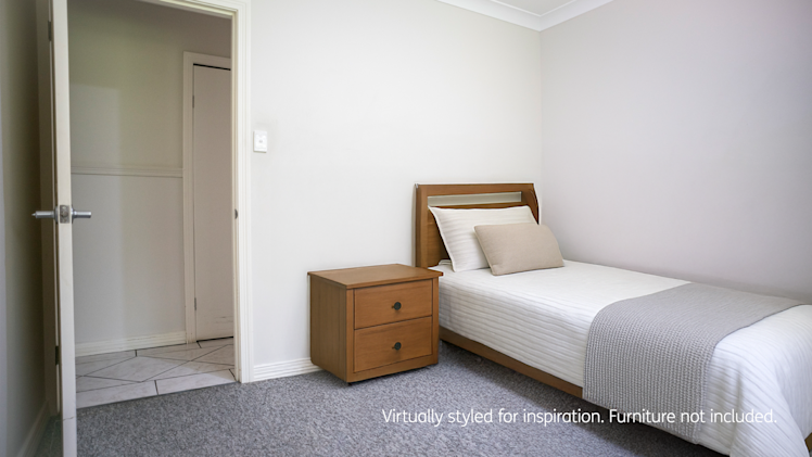 bedroom with a single bed, white bedding, wooden headboard, bedside table with two drawers, and a partially open door leading to a tiled hallway.