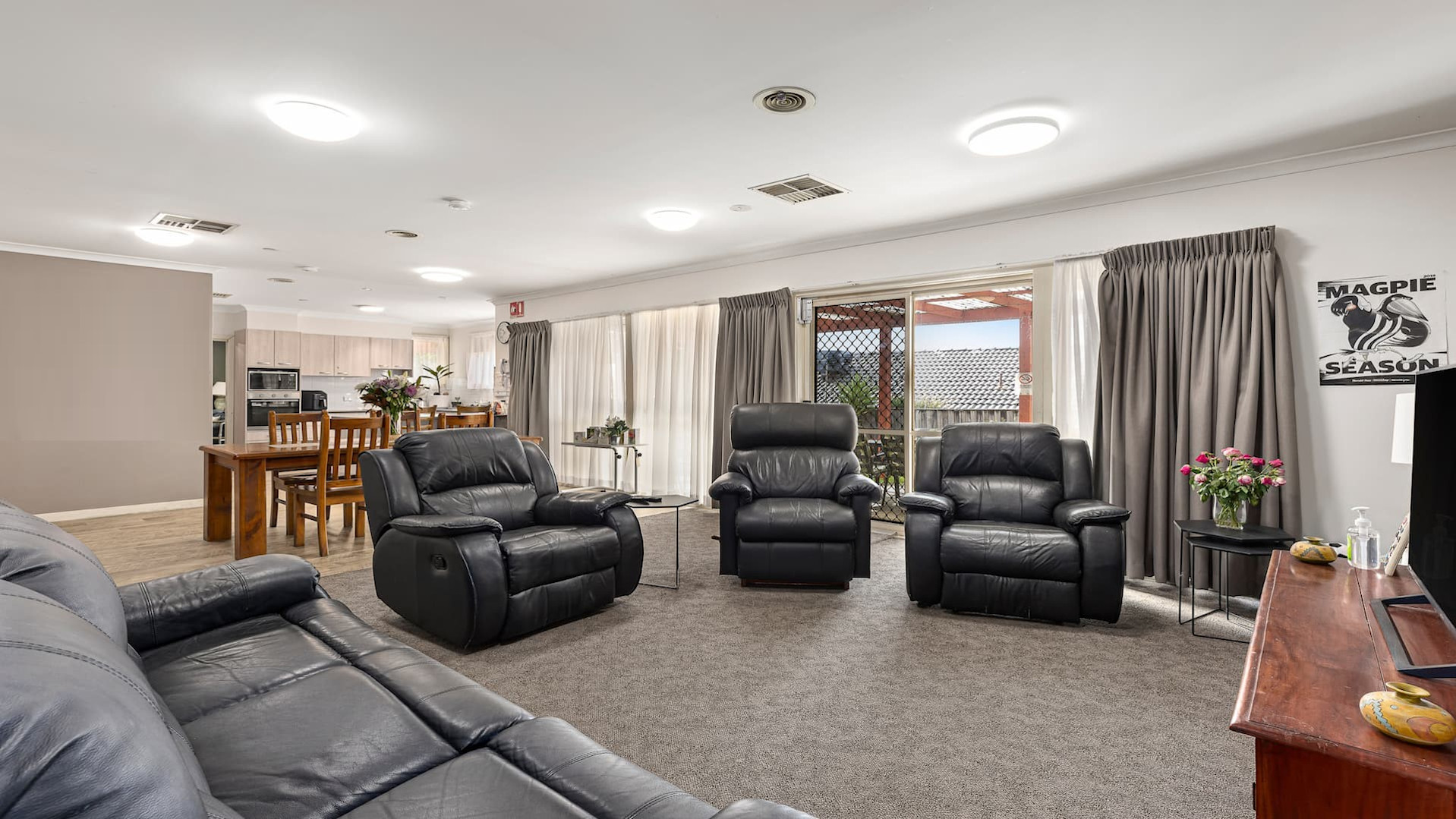 --Open plan kitchen, two windows, dining table and loungeroom.--