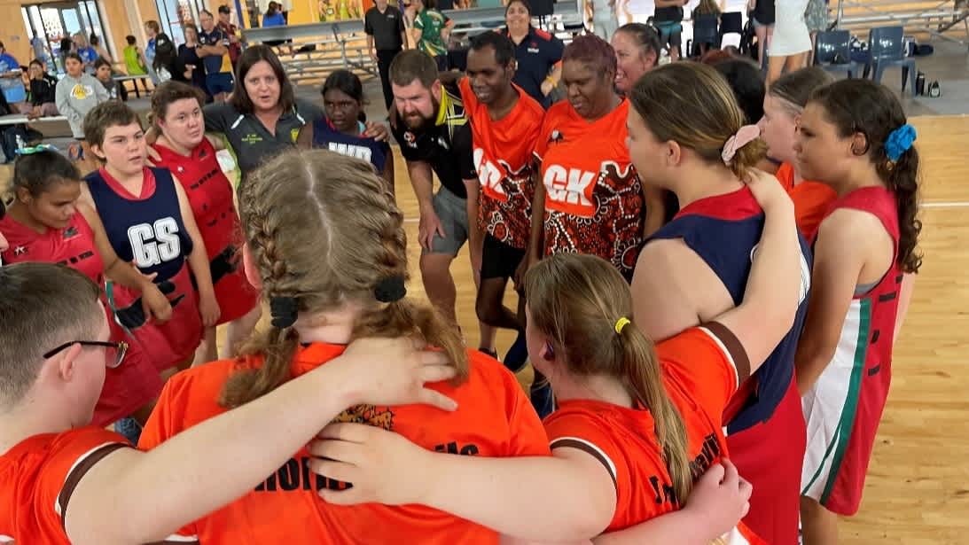 Micky and his team standing together in a huddle.