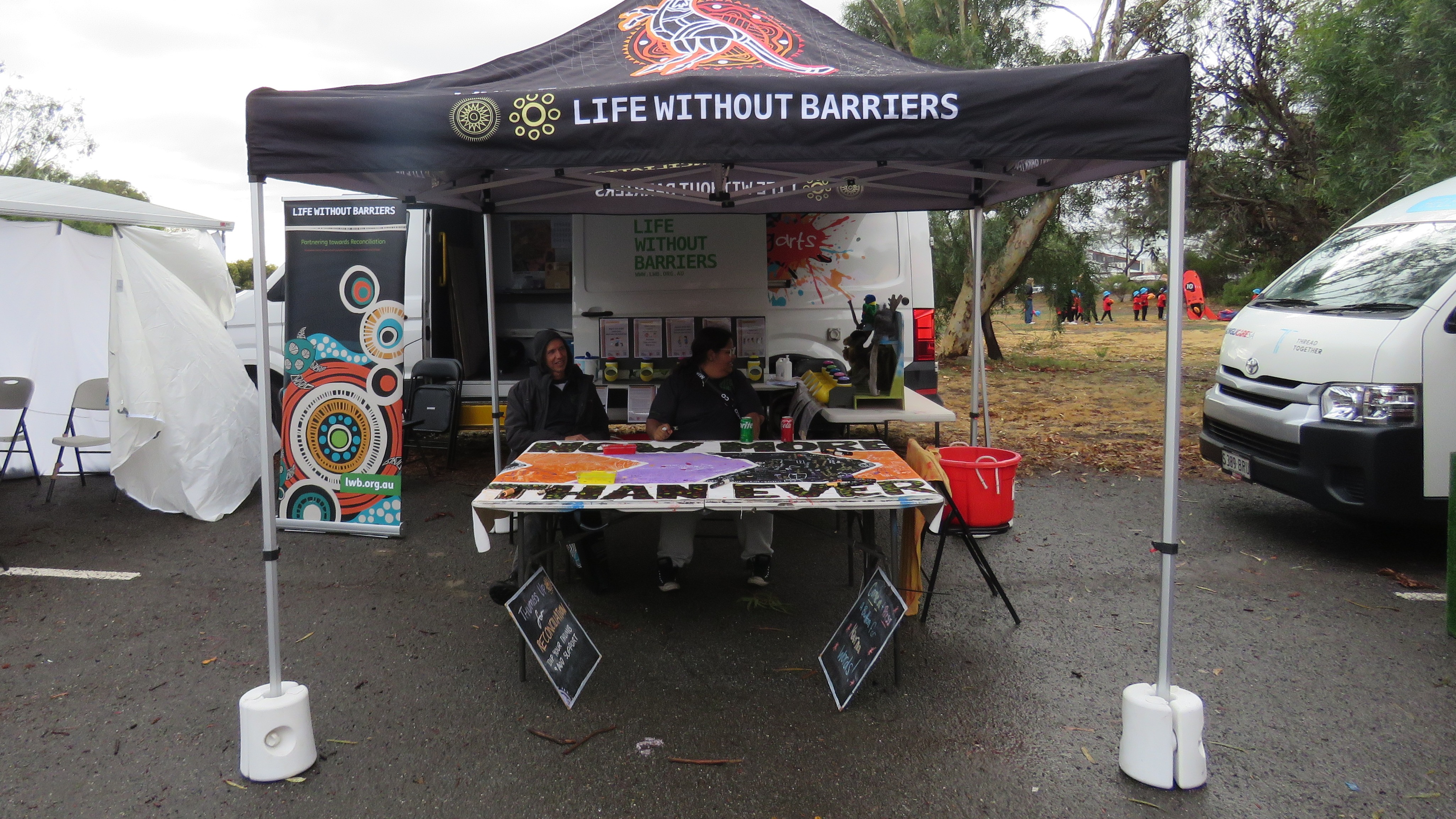 Two staff members at Life Without Barriers Living Arts stall at the 2024 Rec in the West event.