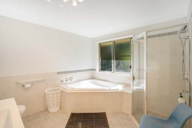 Bathroom with a large corner spa bath and a shower