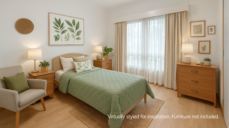 Bright and inviting bedroom with light wood flooring, featuring a single bed with a green quilted cover and decorative pillows, two wooden bedside tables with lamps, a chest of drawers, an upholstered armchair, and botanical-themed artwork on the walls. Large curtained window allows natural light to fill the room.