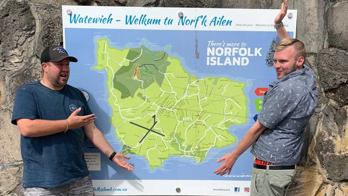 Chad and Lleyton standing by a map of Norfolk Island.