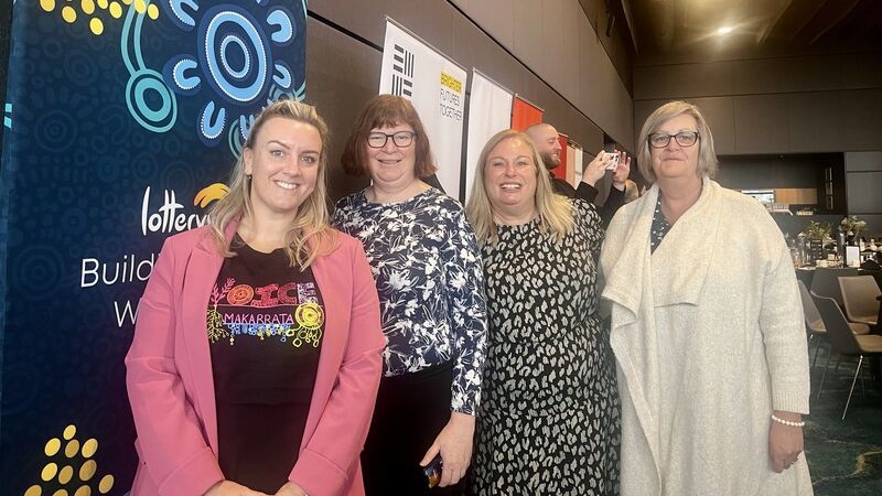  Four people stand as a group and smile at the camera at the Reconciliation WA breakfast.