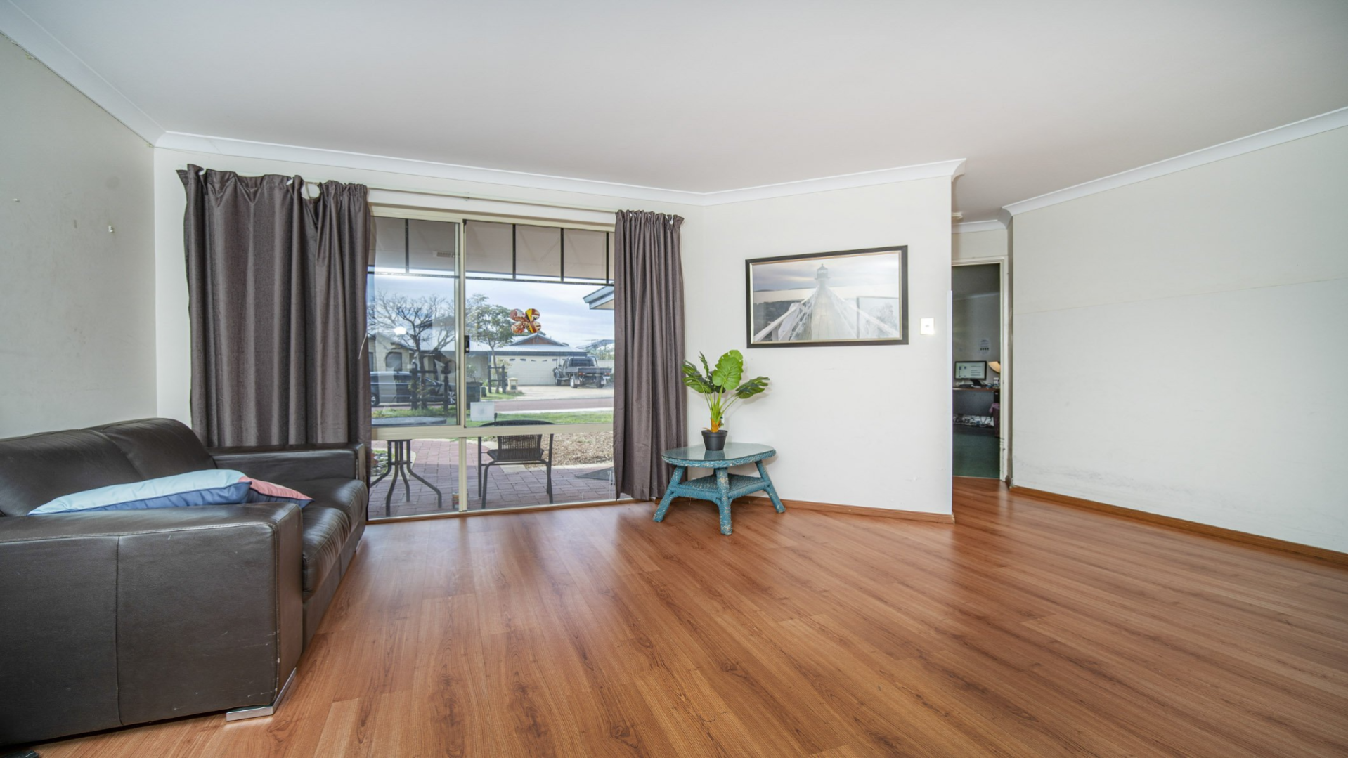 --Lounge room with floorboards, a couch and a small coffee table.--