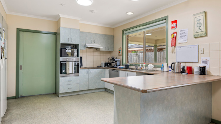 Accessible kitchen with island bench, ample storage and open-plan layout.