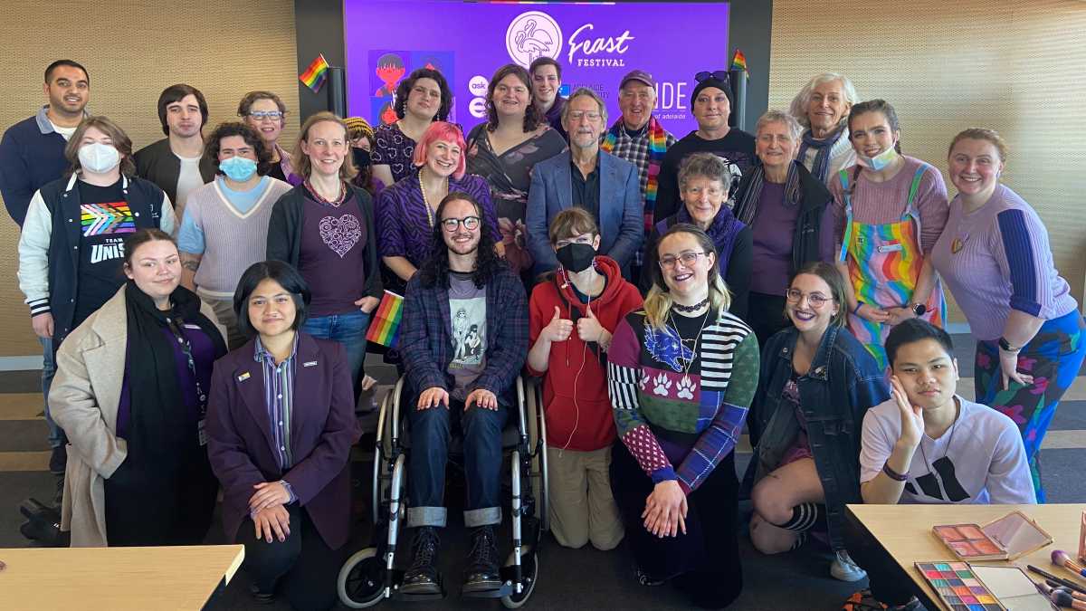 A large group of people wearing purple and smiling.