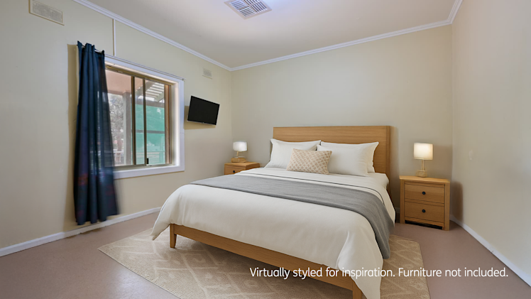 Cosy bedroom with a queen bed featuring white and grey bedding, wooden bedside tables with lamps, a wall-mounted TV, and a large window with dark curtains.