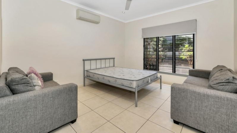 Bedroom with tiled floor, aircon, ceiling fan, lounges, bed.