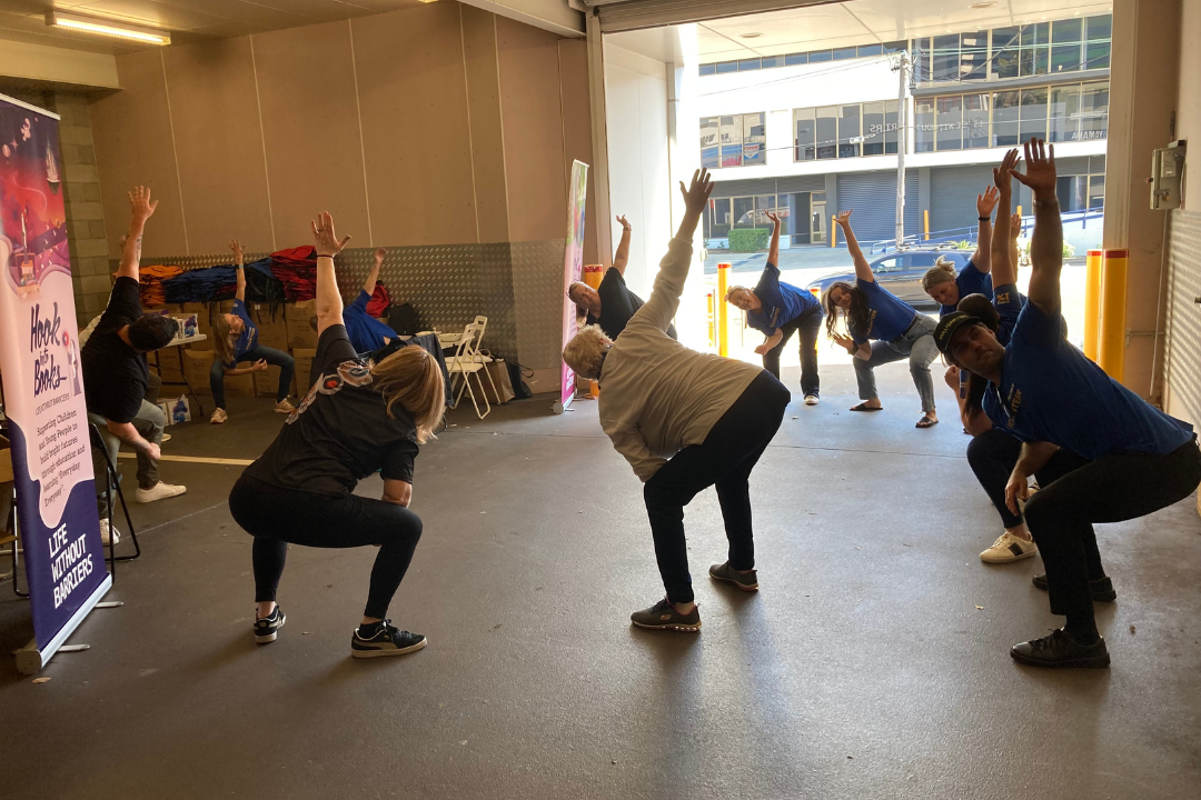 Staff and volunteers engaging in a stretching activity.