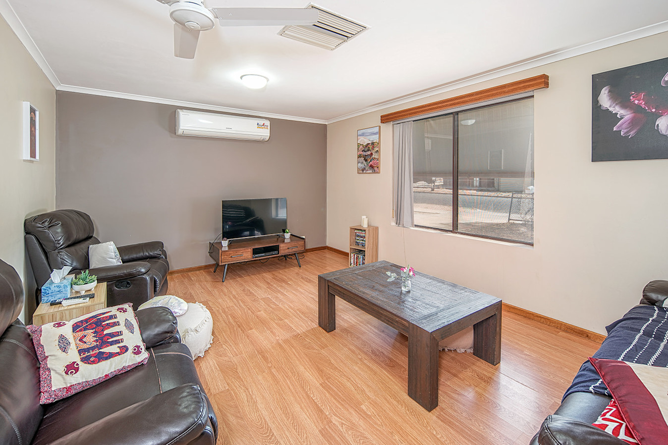 --Living room with wooden floors, window, tv and lounges.--