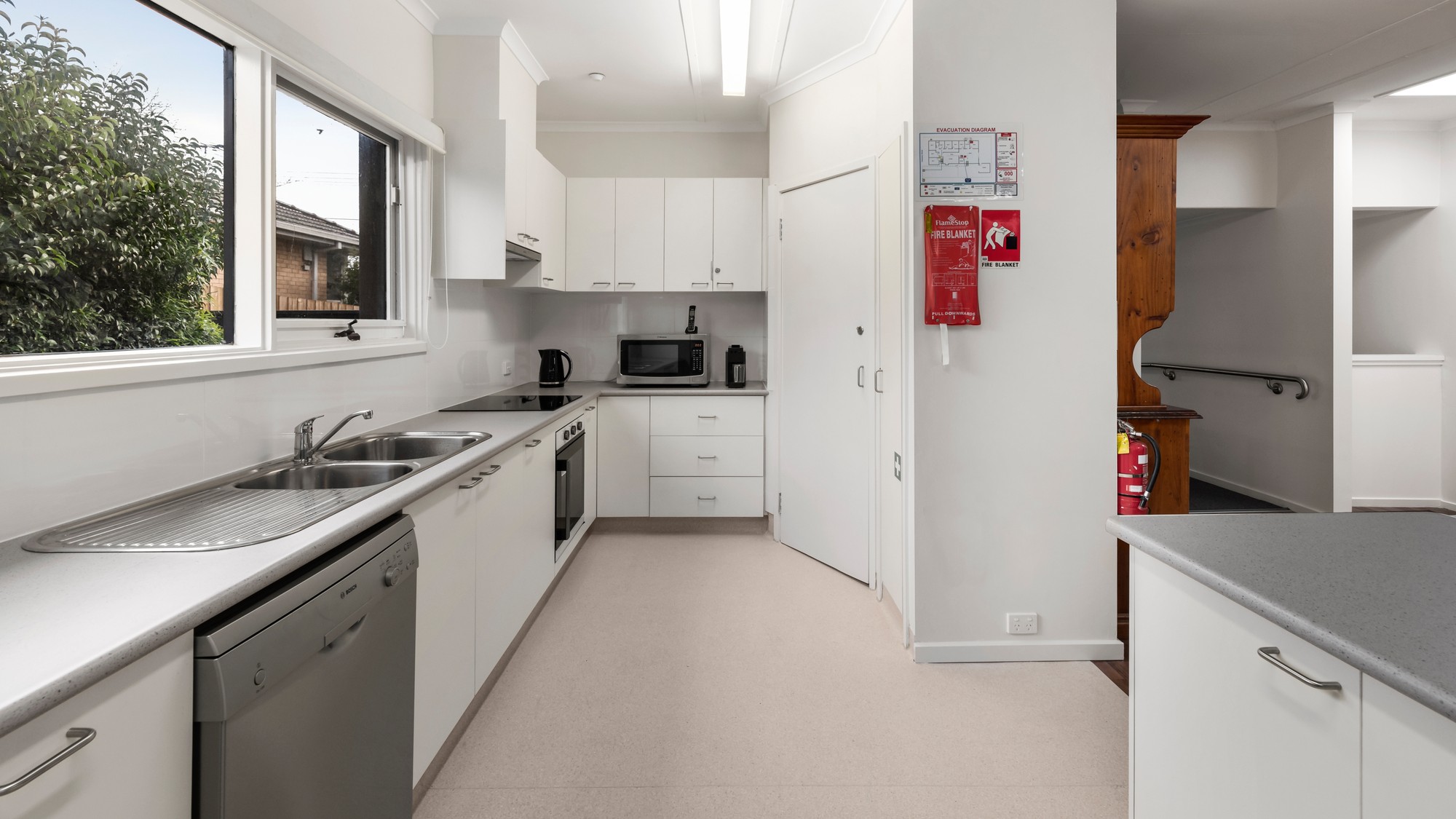 Large kitchen with a dishwasher, ample bench space and storage.