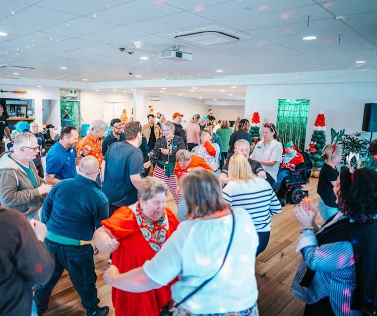 Attendees at the event wearing Christmas themed clothing and dancing.