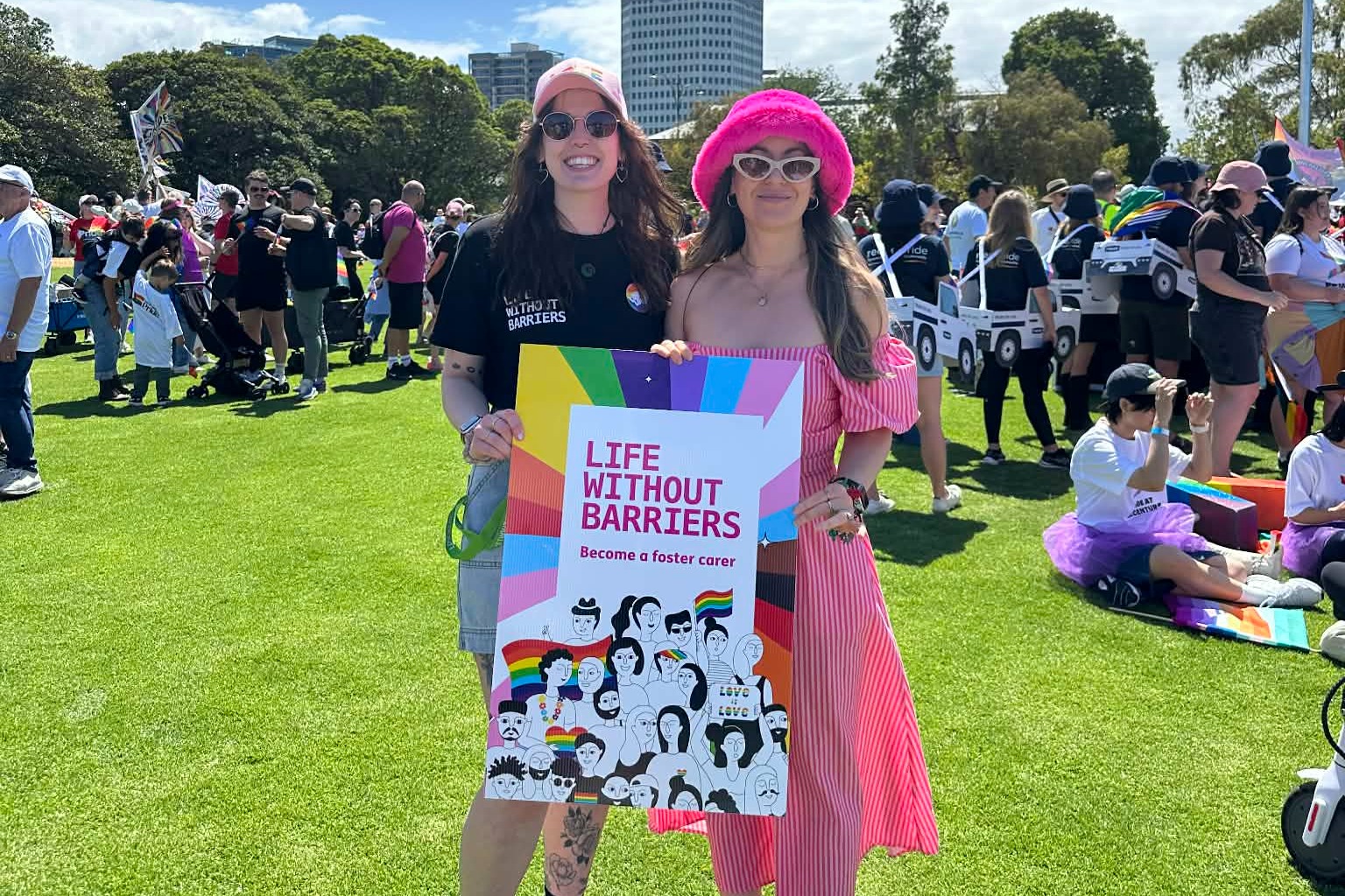 Trelawney and Jacintha holding a Life Without Barriers 'Become a foster carer' banner and smiling at the camera.