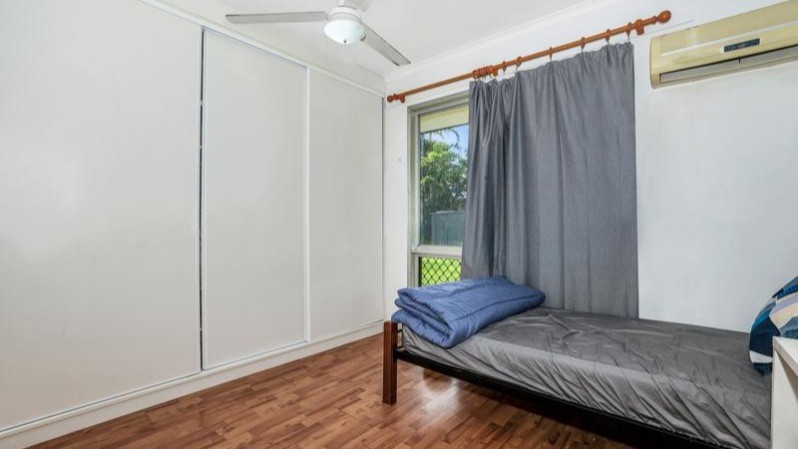 --Bedroom with sliding cupboards, single bed, aircon, wooden floors and large window.--