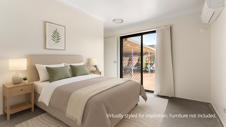 A contemporary bedroom featuring a beige upholstered bed with green accent pillows, twin bedside tables with lamps, and sliding doors leading to a tiled outdoor patio.