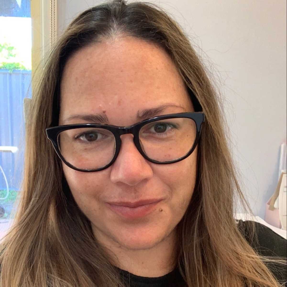 Close up of Shannon Mackie, Gumbaynggirr woman, State Manager Aboriginal & Torres Strait Islander, Cultural Support, Leadership & Governance. Shannon has long light brown hair and is wearing glasses and a black top.