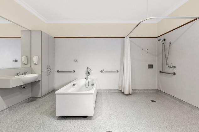 Open accessible bathroom. white walls and tiled white floors. 