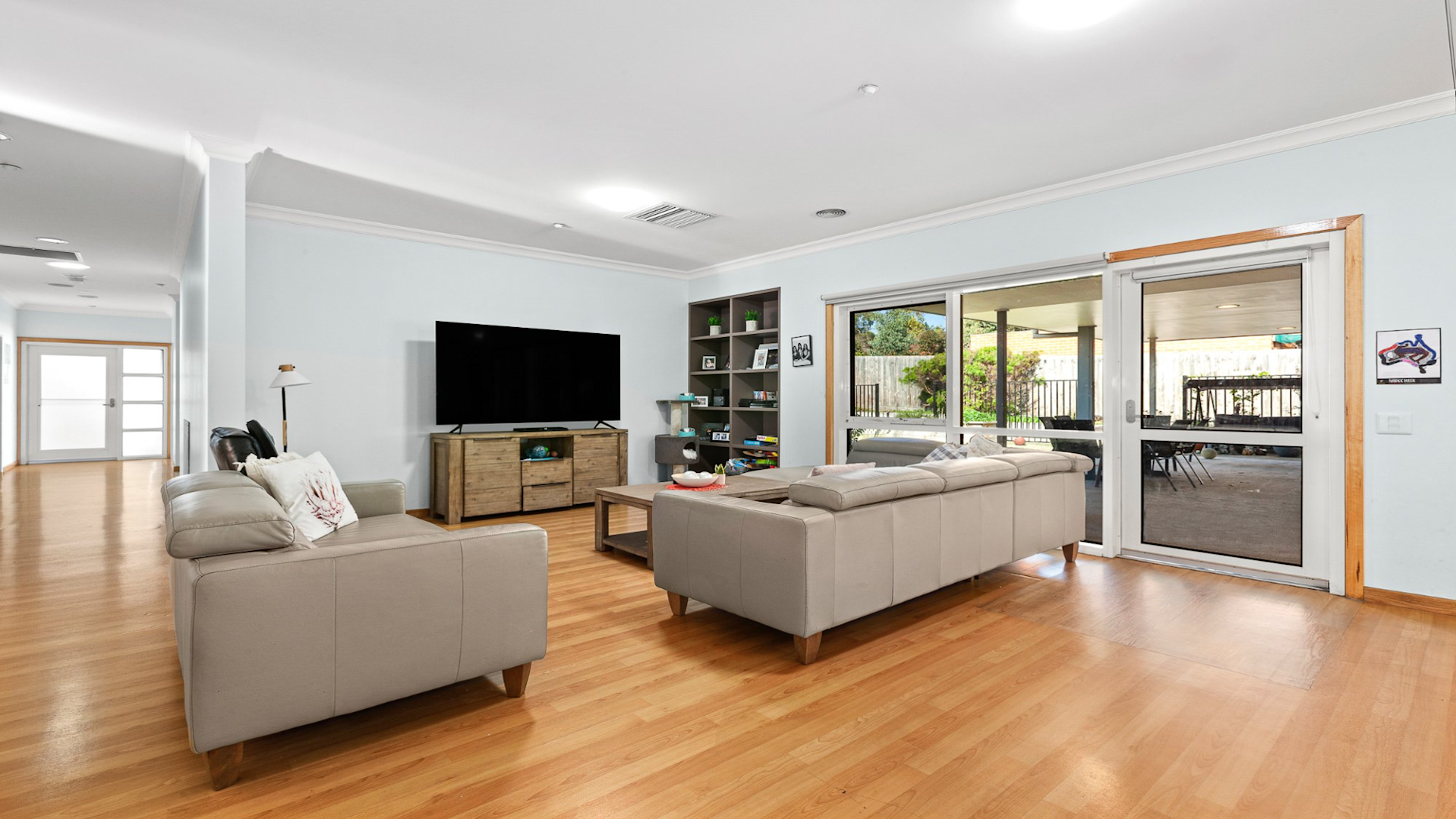 --Loungeroom with two couches, a TV on a TV unit, coffee table and built in shelves.--