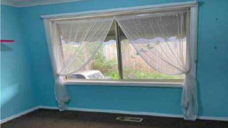 Bright blue bedroom with window and carpet.