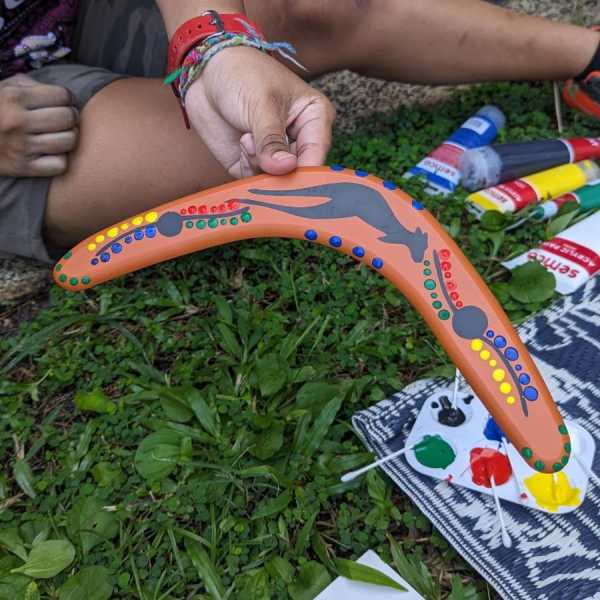 A close-up of a boomerang hand painted by a young person.