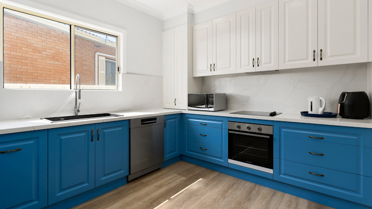 Large kitchen with blue and white cabinets.