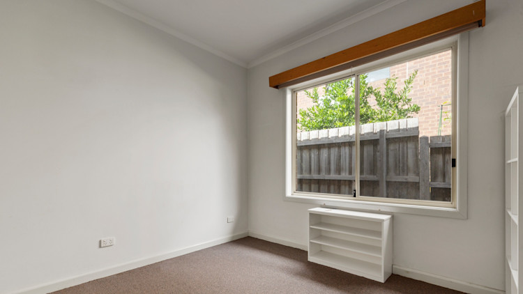 --Bedroom with carpet, white calls, large window and shelves.--