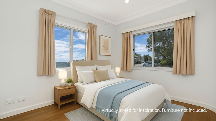 Bright bedroom with double windows, beige curtains, light bedding with a blue throw, and matching bedside tables.