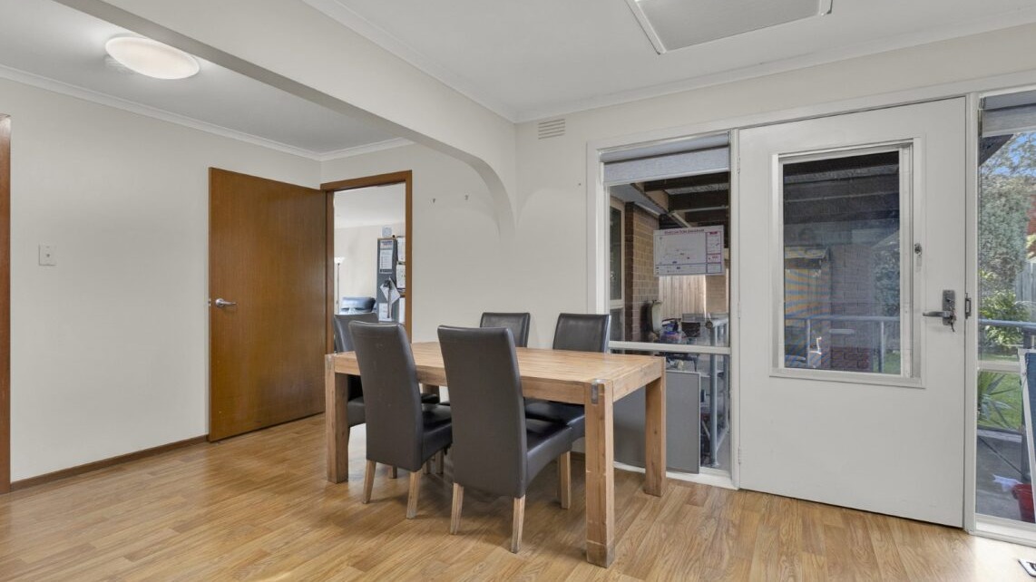 Dining area with table and chairs, timber flooring and access to outdoor area.