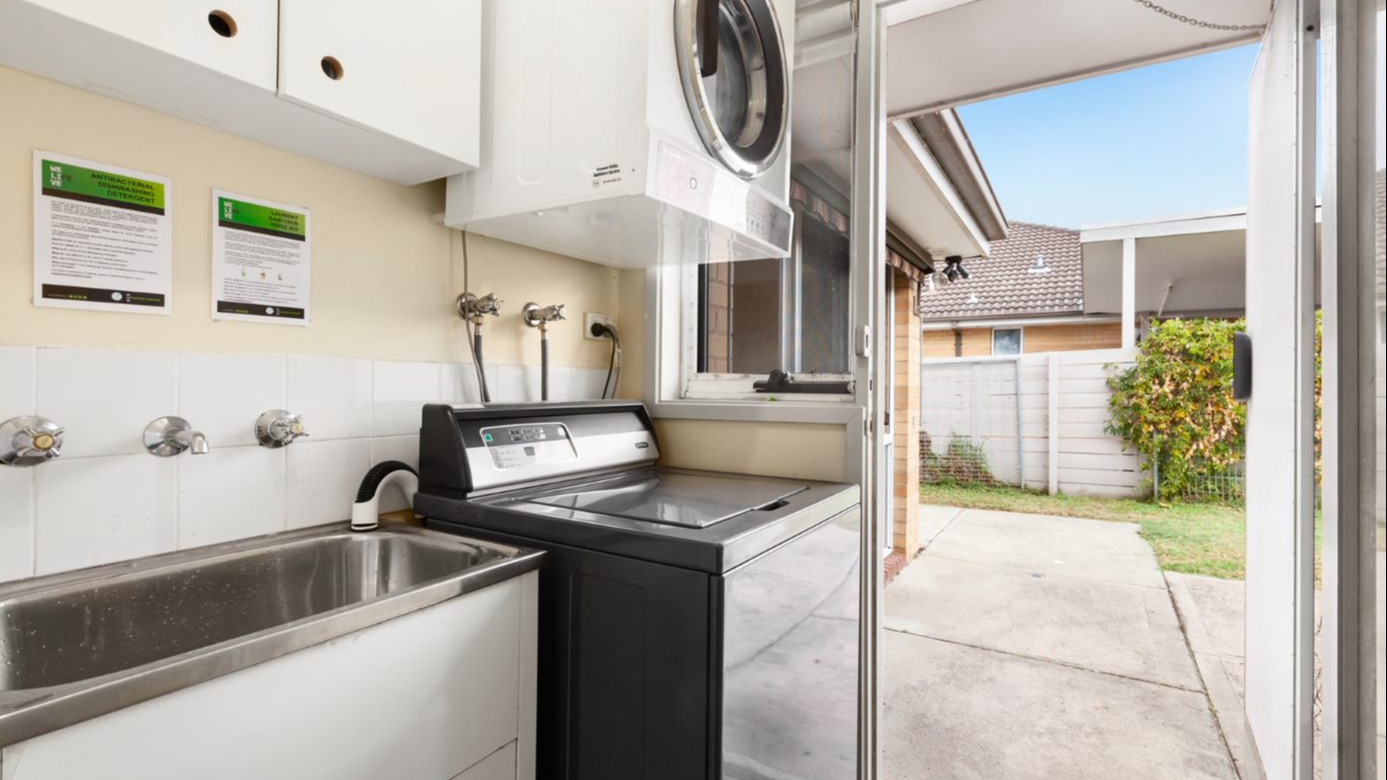 Laundry with a large sink, washing machine and dryer.