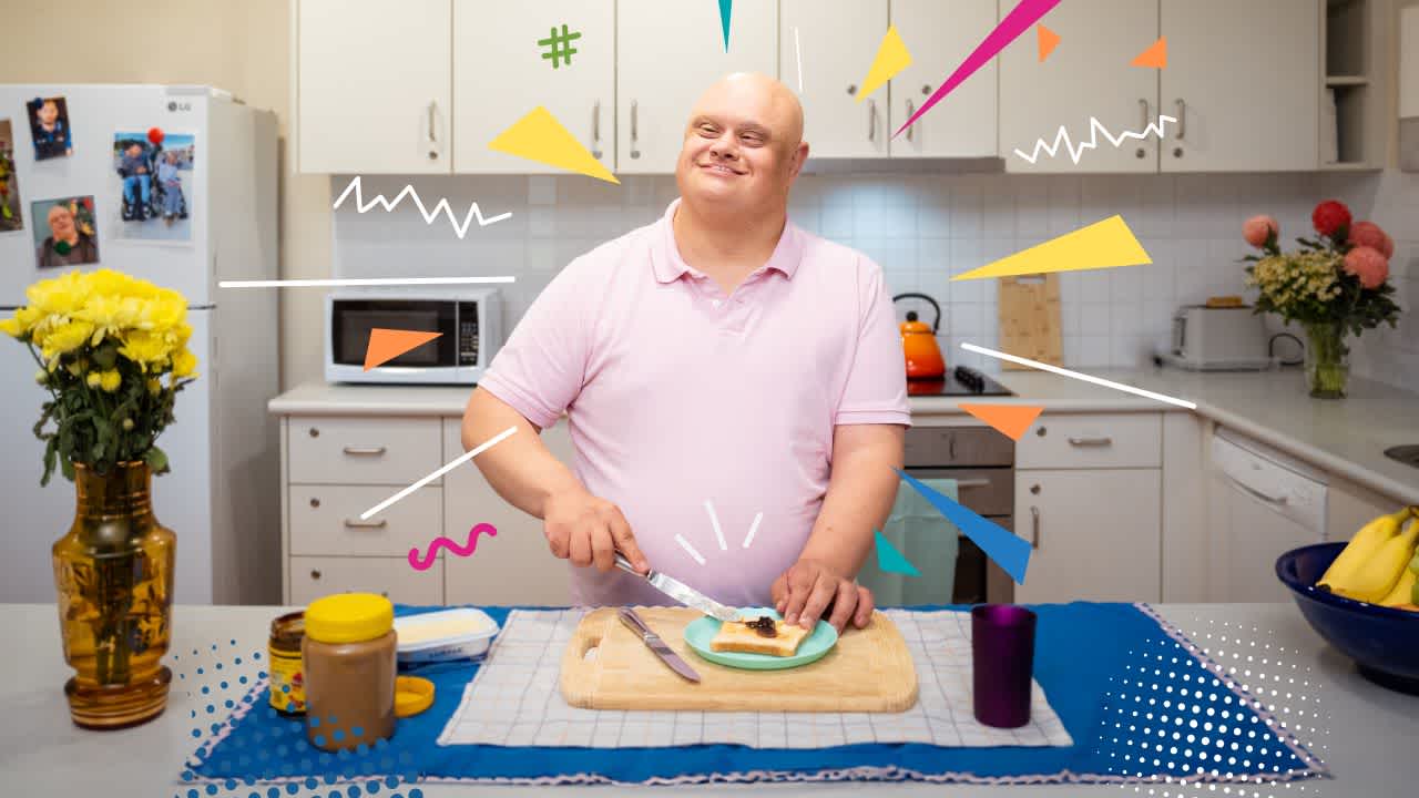A man wearing a light pink polo is making breakfast