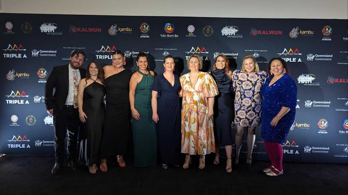 A large group of staff gather for a group photo at the Brisbane NAIDOC Ball.