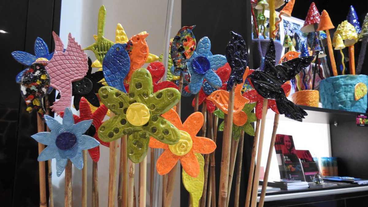 Ceramic garden art in the shape of birds and flowers.