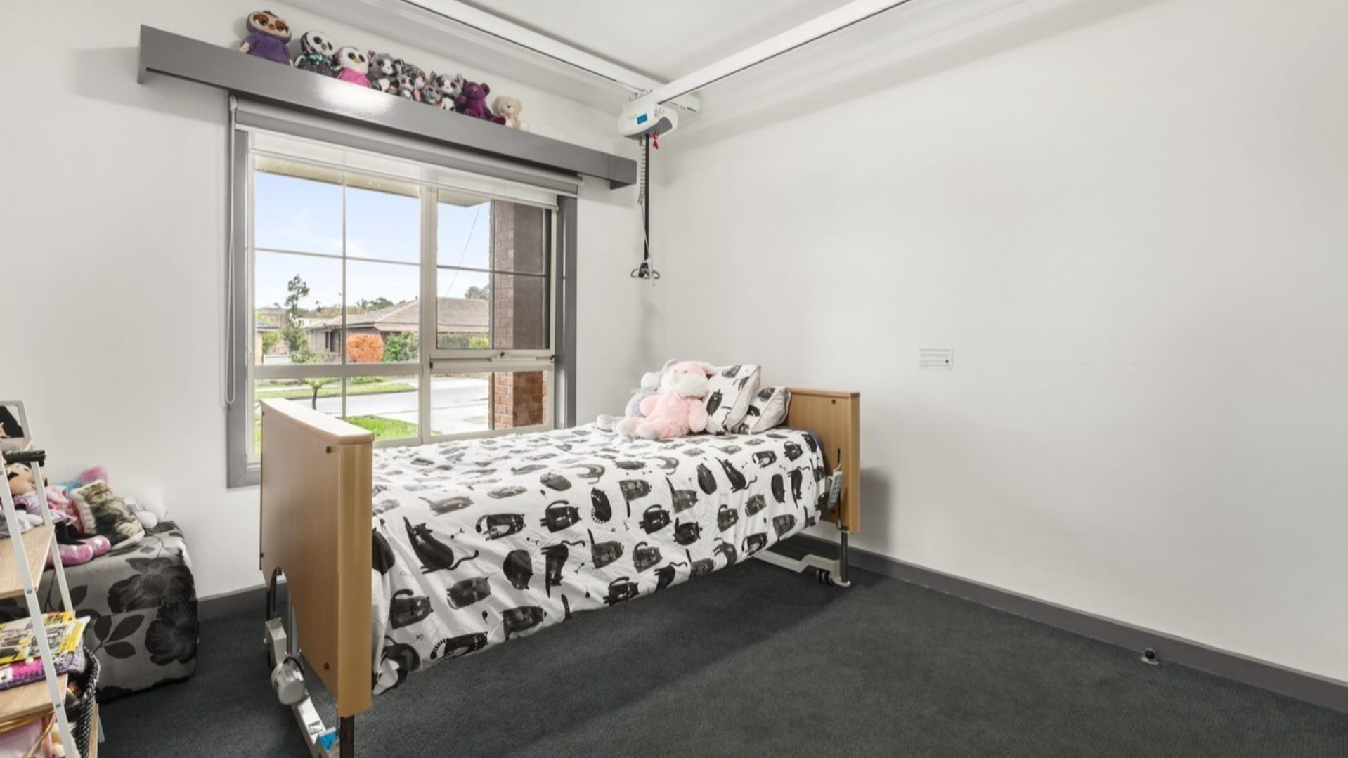 Bedroom with a single bed, arm chair and shelf.