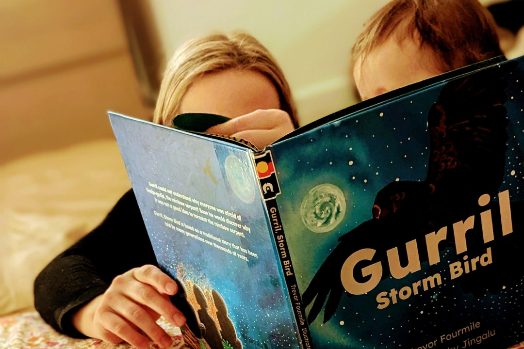 Two young people reading a picture book.