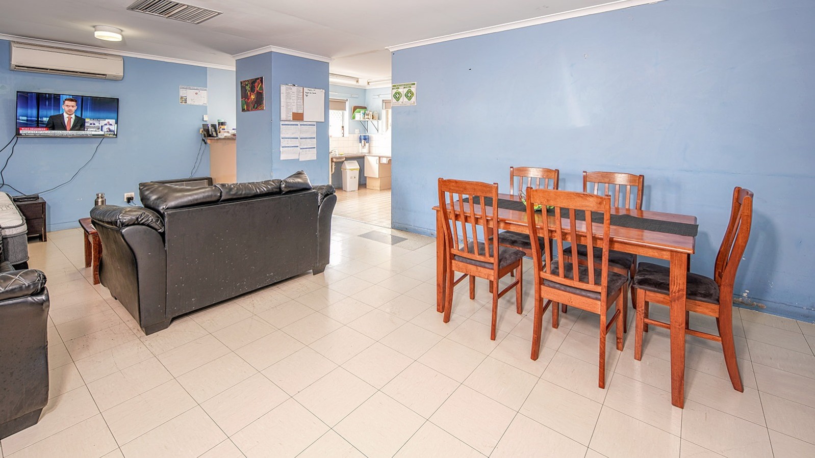 --Tiled floor, lounges, kitchen table and blue walls.--