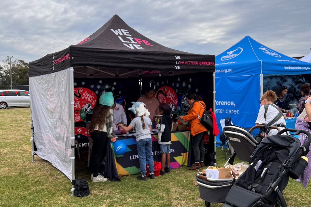 Children engaging with the creative activity at Life Without Barriers booth.