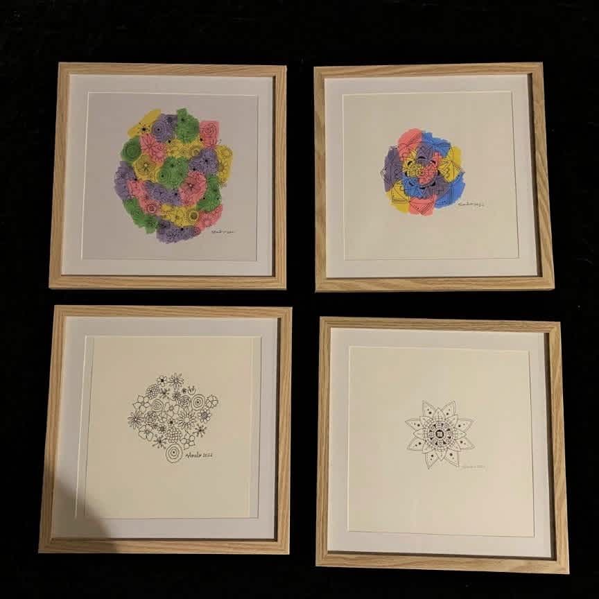 Flatlay of Sarah's four art pieces in frames.